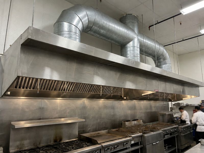 Hệ thống chụp hút inox và đường ống gió hoàn thiện giúp gom khói triệt để cho bếp nhà hàng.