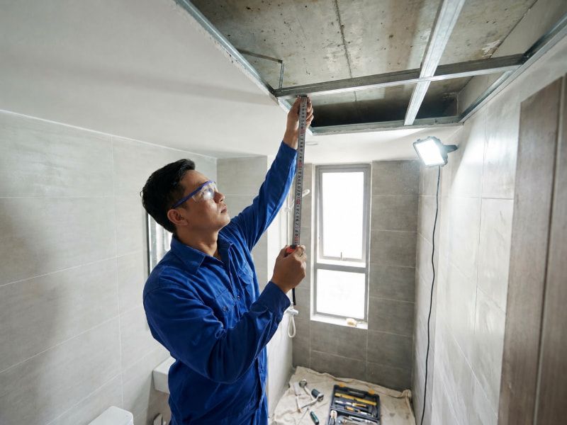 Kích thước quạt hút âm trần phổ biến và cách chọn chuẩn xác 4 Kỹ thuật viên đo khoảng trống âm trần để kiểm tra chiều sâu lắp quạt trước khi thi công.