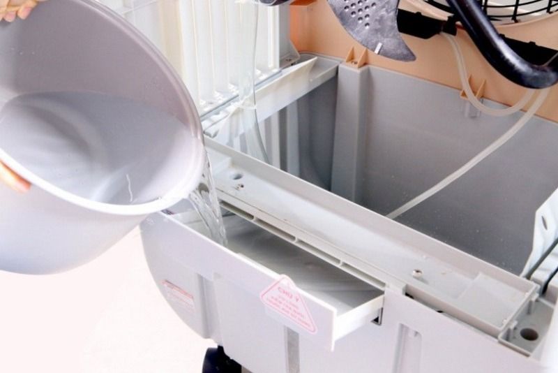Đổ nước sạch vào bình chứa đến mức quy định